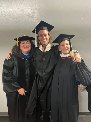 MA student with faculty at graduation