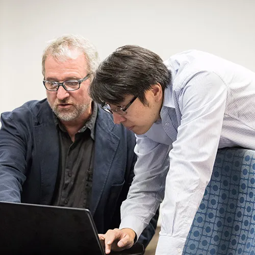 professor and student at laptop