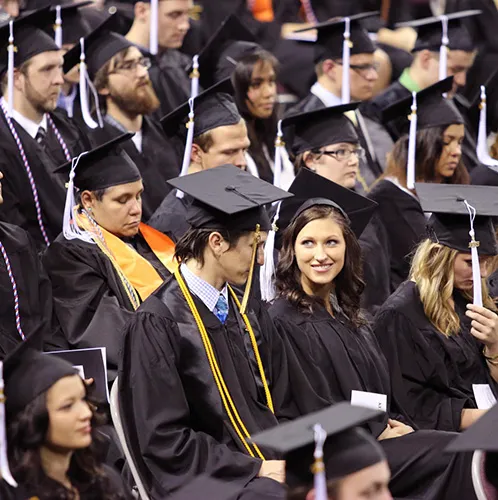 students in gowns at graduation