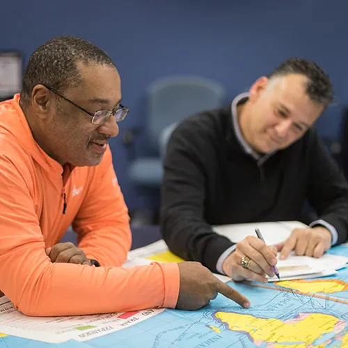 faculty and student looking at map