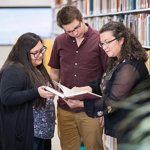 Faculty discussing book with students